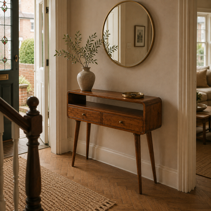 Chestnut console table with curved front styled in a warm Victorian terrace hallway.